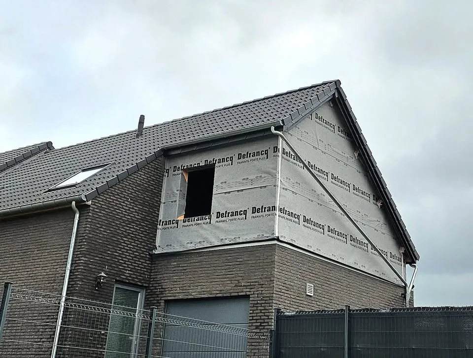 Extension en bois avec terrasse, construite au-dessus d'un garage.